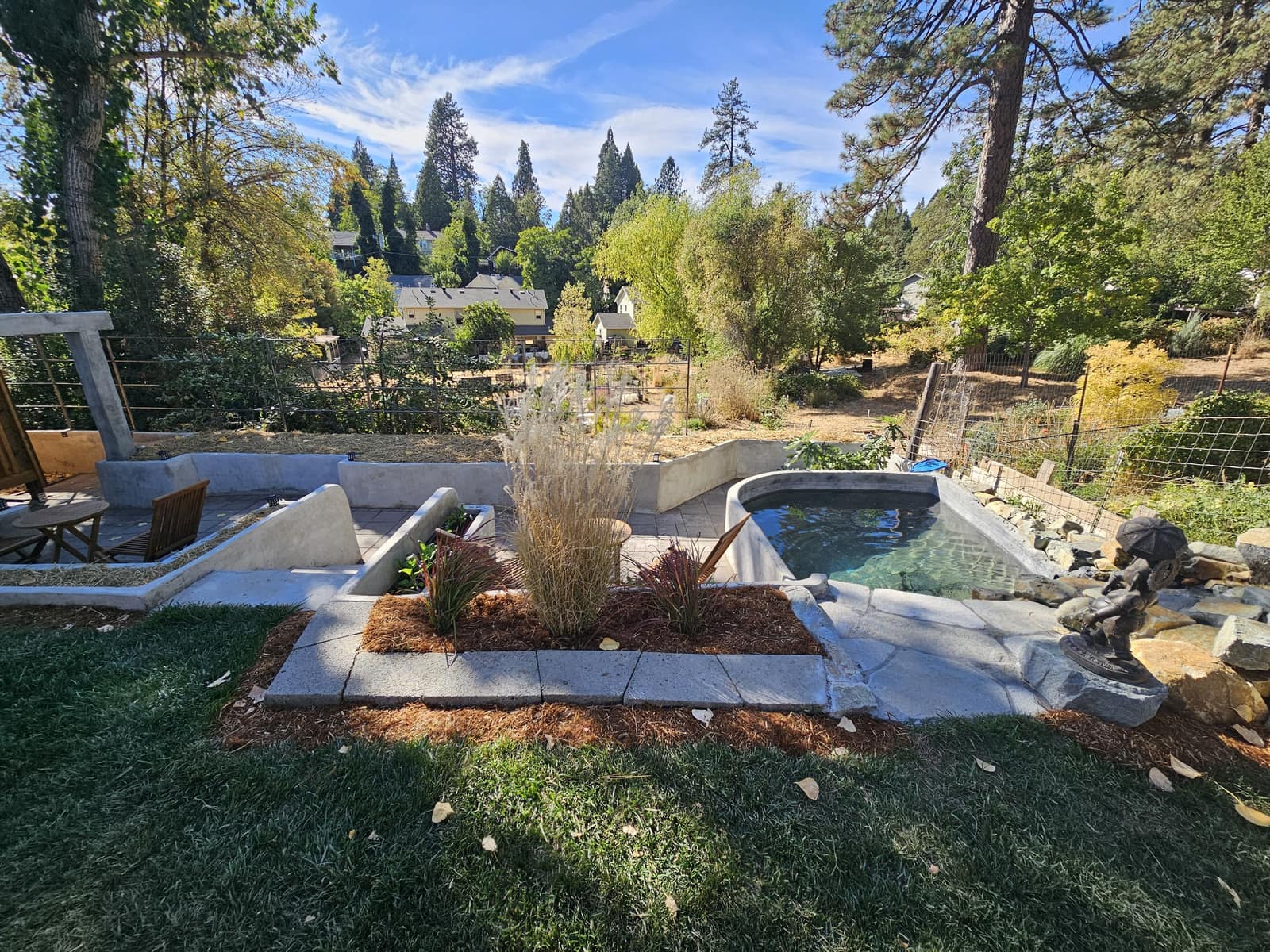 The Sanctuary garden, looking from the lawn toward the dipping pond and pines.