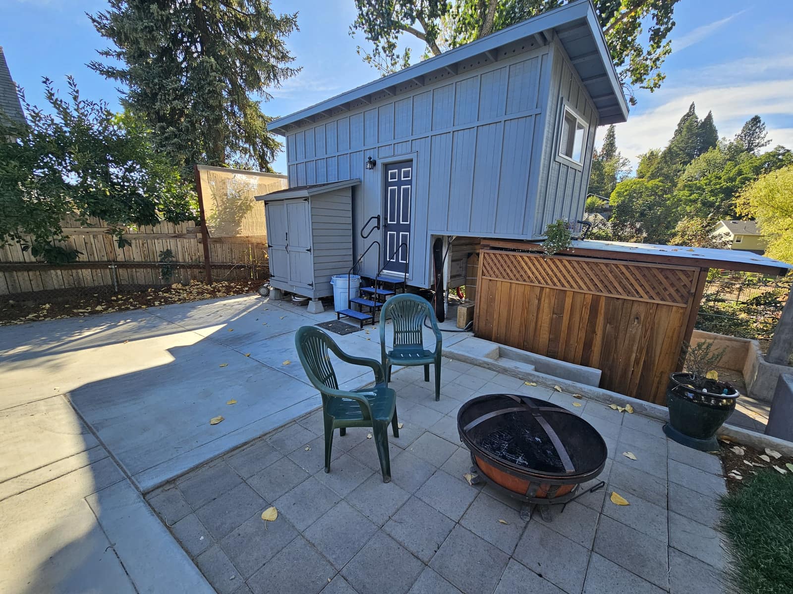 The Hideaway, a small blue-gray house, with a fire pit on the patio.