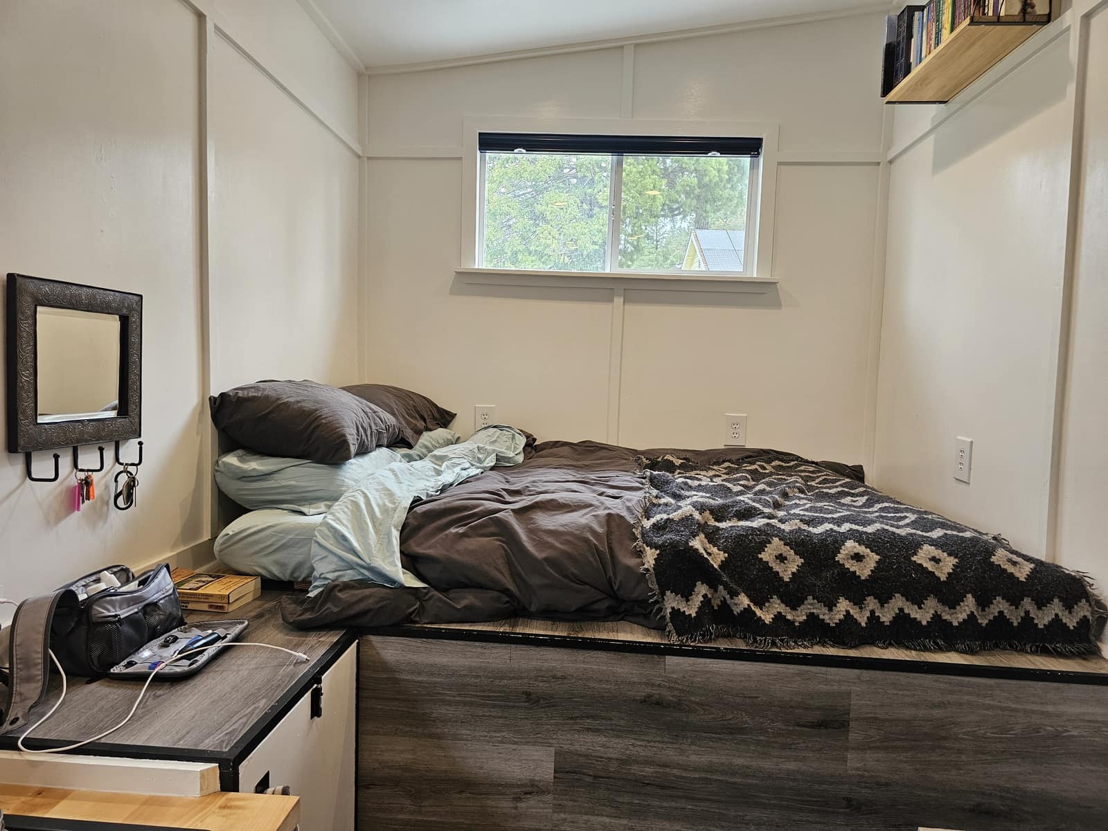 Sleeping loft in The Hideaway with a window looking into the trees.